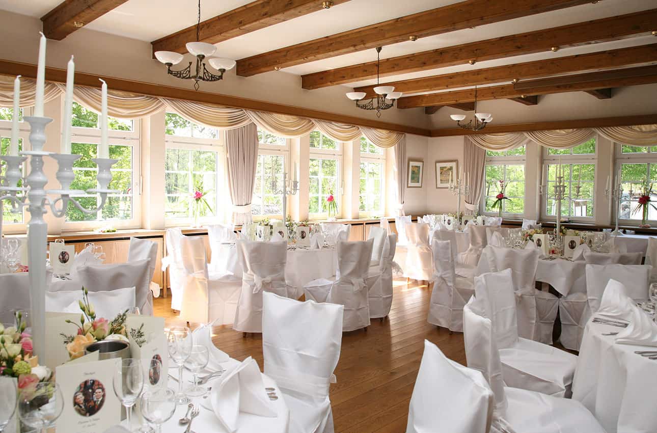 WasWoFinden Hochzeit auf Hof Sudermuehlen Weiß geschmückter Raum mit runden Tischen