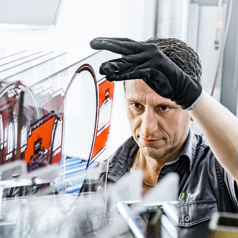 Mitarbeiter von Printotec begutachtet den Siebdruck