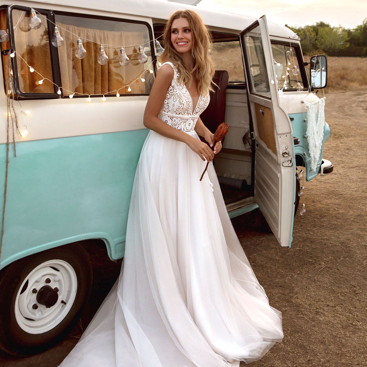 Frau im Boho Brautkleid vor Bus