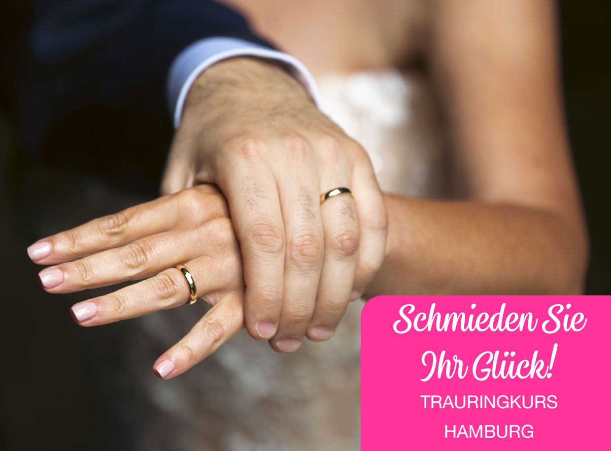 Männliche Hand hält die Hand einer Frau, beide tragen Eheringe.